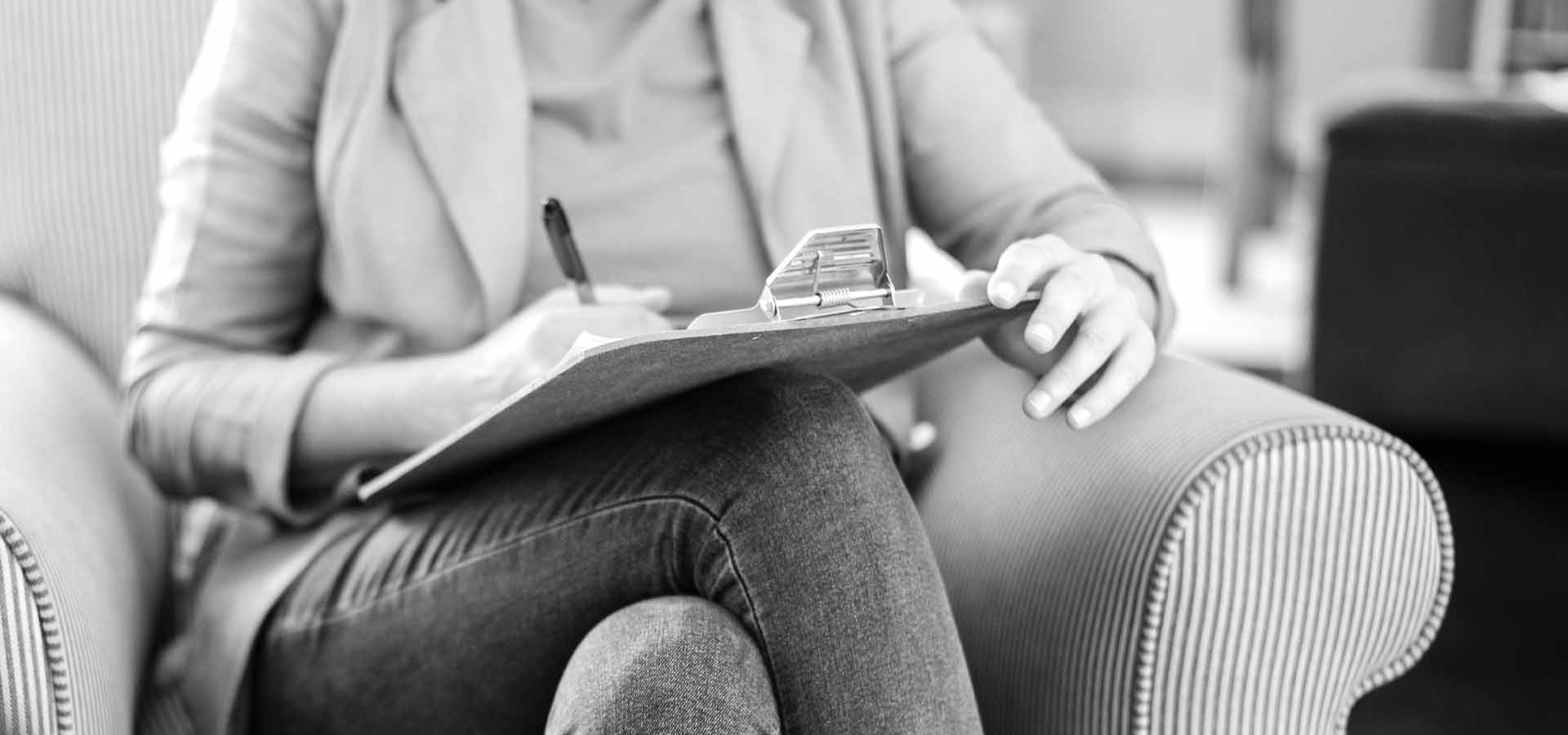 Psykoterapeuter sitter och antecknar under samtal